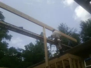 Carpenter setting a ridge beam over a new addition frame — Ice Dam Removal by Roofing Brothers in Montgomery