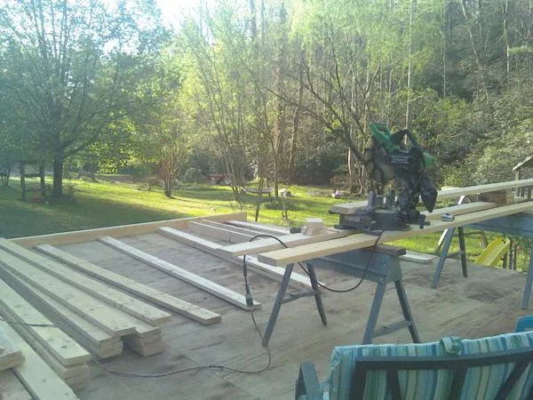 Miter saw and framing lumber on a deck under construction in Montgomery
